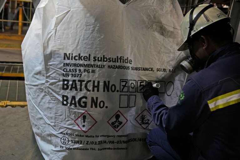 A worker writes batch numbers on a bag of nickel matte at PT Vale Indonesia's processing plant in Sorowako, South Sulawesi, Indonesia, Tuesday, Sept. 12, 2023. (AP Photo/Dita Alangkara)