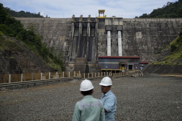 Employees talk near Balambano hydroelectric plant, one of three dams that powers PT Vale Indonesia's processing plant, in Sorowako, Indonesia, Wednesday, Sept. 13, 2023. Vale churns out 75,000 tons of nickel a year for use in batteries, electric vehicles, appliances and many other products. (AP Photo/Dita Alangkara)