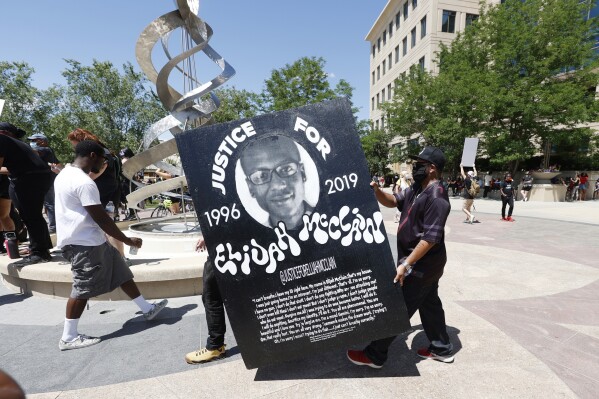 FILE - In this June 27, 2020, file photo, demonstrators carry a giant placard during a rally and march over the death of Elijah McClain outside the police department in Aurora, Colo. Prosecutors are expected to present opening statements Wednesday, Sept. 20, 2023, in the trial of Randy Roedema and Jason Rosenblatt on manslaughter, criminally negligent reckless homicide and assault charges. They, a third officer and two paramedics were indicted in 2021 by a state grand jury convened following an outcry over McClain’s death. (AP Photo/David Zalubowski, File)