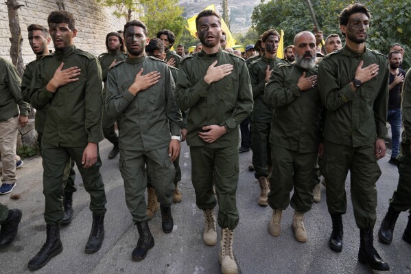 FILE - Hezbollah fighters mourn, as they attend the funeral procession of their two comrades who were killed by Israeli shelling, in Kherbet Selem village, south Lebanon, Tuesday, Oct. 10, 2023. (AP Photo/Hussein Malla, File)