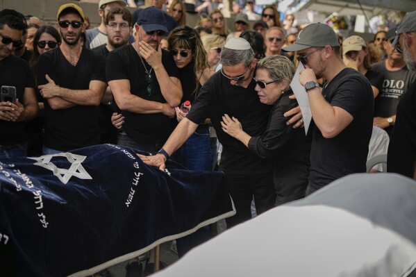 Mourners gather in grief around the bodies of Danielle Waldmann and her partner Noam Shai during their funeral in the northern Israeli town of Kiryat Tivon Thursday, Oct. 12, 2023. (AP Photo/Ariel Schalit)