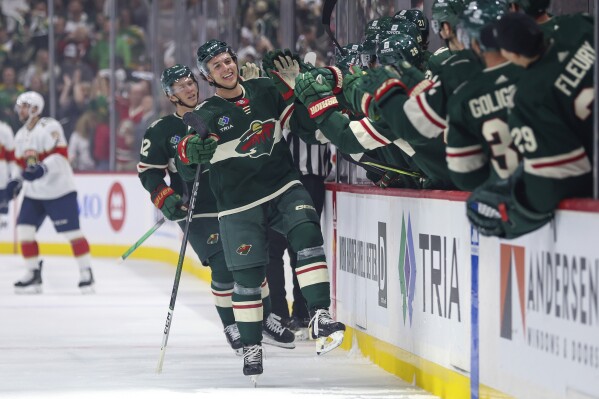Minnesota Wild defenseman Brock Faber, front left, is congratulated for his goal against the Florida Panthers during the first period of an NHL hockey game Thursday, Oct. 12, 2023, in St. Paul, Minn. (AP Photo/Matt Krohn)