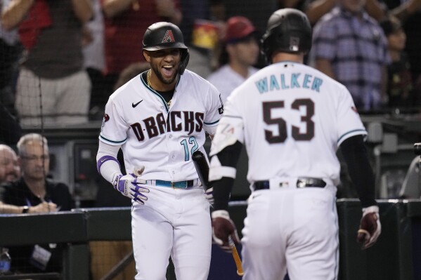 Arizona Diamondbacks' Christian Walker (53) celebrates his home run with teammate Lourdes Gurriel Jr. during the third inning in Game 3 of a baseball NL Division Series against the Los Angeles Dodgers, Wednesday, Oct. 11, 2023, in Phoenix. (AP Photo/Ross D. Franklin)