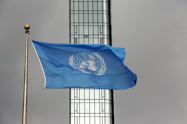 FILE - The UN flag flies on a stormy day at the United Nations during the United Nations General Assembly on Thursday, Sept. 22, 2022. A U.N. official says the eight peacekeepers have been suspended and detained in eastern Congo on allegations of sexual exploitation. The United Nations said on Wednesday, Oct. 11, 2023 that it has taken “strong measures in response to reports of serious misconduct by peacekeepers.” The peacekeepers have been confined pending further details and a full investigation. (AP Photo/Ted Shaffrey, File)