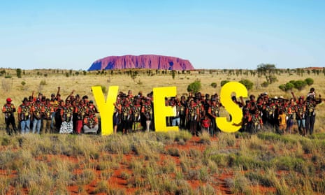 Handout photograph released by Central Land Council shows the elected grass-roots representatives of remote communities in Central Australia posing in front of the iconic landmark the Uluru with large yellow letters forming the word yes