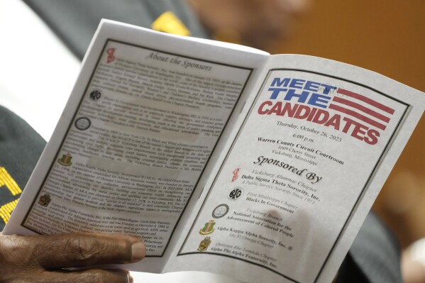 An attendee to a candidates forum reviews a list of those people seeking a statewide office in the November 7 election, on Oct. 26, 2023, in Vicksburg, Miss. (AP Photo/Rogelio V. Solis)